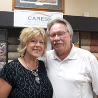 A man and woman standing in front of a wall.