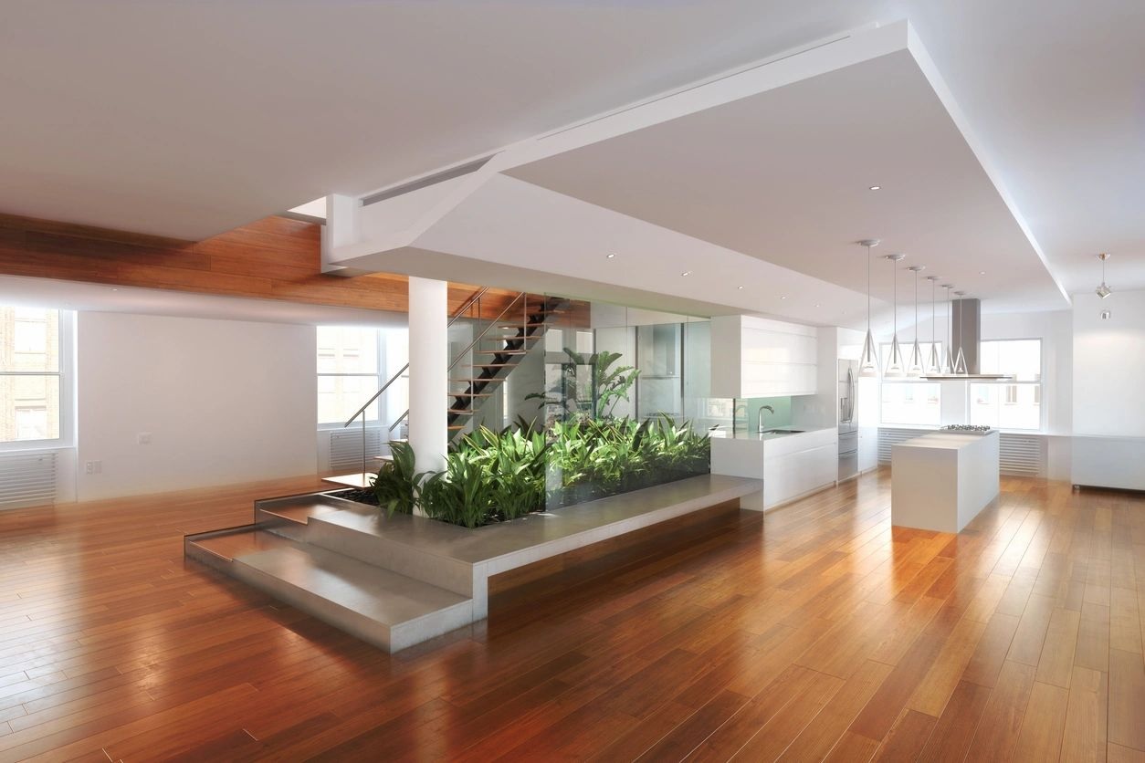 A large room with wooden floors and plants.